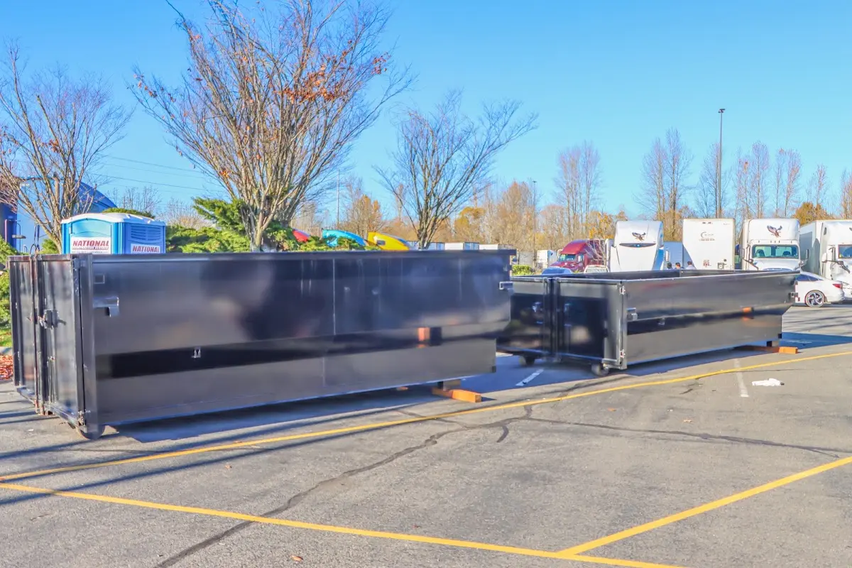Professional dumpster rental service with roll-off container on residential driveway in West Lafayette